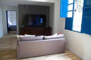 uma sala de estar com um sofá e uma televisão de ecrã plano em Casa com piscina e churrasqueira em Lagoa Santa MG em Lagoa Santa