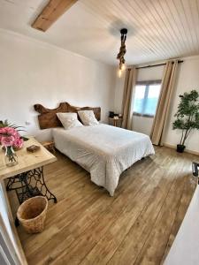 ein Schlafzimmer mit einem großen Bett und einem Tisch in der Unterkunft U PASTURELLU in Pioggiola