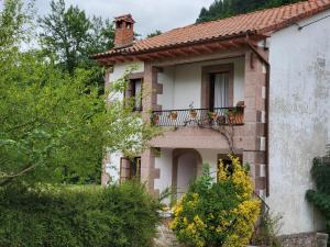 a house with a balcony on the side of it at Casa de los Valles en RioNansa in Puentenansa