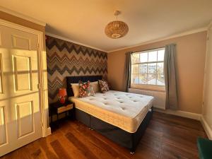 una camera da letto con un grande letto e una finestra di Funky 1 Bedroom Apartment Next to the Sea a Brighton & Hove