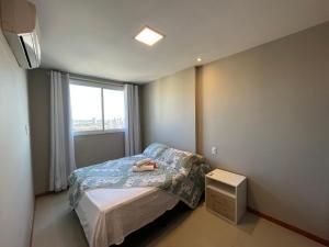 a small bedroom with a bed and a window at ITAPARICA RELAX INN! Portaria e bar 24H! in Vila Velha