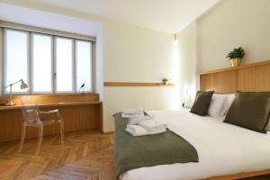 um quarto com uma cama, uma secretária e uma cadeira em Sweet Inn - Maison Laghetto em Milão