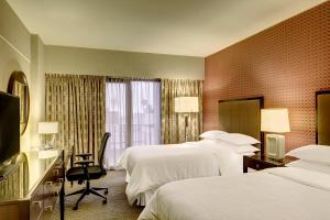 a hotel room with two beds and a television at Sheraton Lima Historic Center in Lima