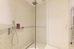 um chuveiro com uma porta de vidro na casa de banho em Sweet Inn - Maison Laghetto em Milão
