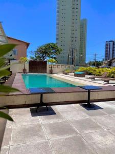 a ping pong table in front of a swimming pool at Flats em Salvador à 150m da praia in Salvador