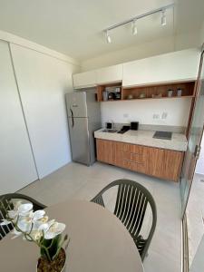 a kitchen with a table and a refrigerator at Flats em Salvador à 150m da praia in Salvador