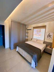 a bedroom with a large bed with a window at Flats em Salvador à 150m da praia in Salvador