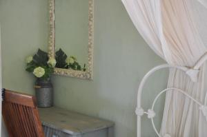 een kamer met een tafel, een spiegel en een gordijn bij Mezzao in Kounopetra