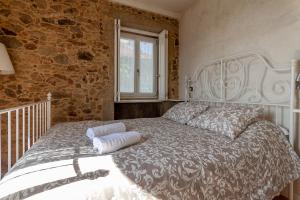 a bedroom with a bed with a stone wall at Villa Redouça in Cedrim