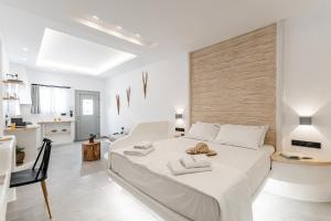 ein weißes Schlafzimmer mit einem großen weißen Bett in einem Zimmer in der Unterkunft Adama's Suites in Naxos Chora