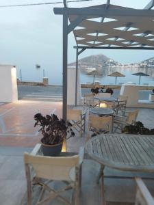 a patio with tables and chairs and a view of the water at Alea Mare Hotel in Alinda