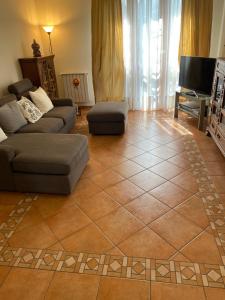 uma sala de estar com um sofá e piso em azulejo em Accanto a Firenze em Prato