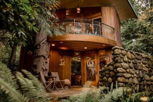 a wooden house with a balcony on top of a tree at Sanctuary Seaside in Eastsound