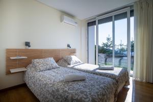 a bedroom with two beds and a large window at Villa Redouça in Cedrim
