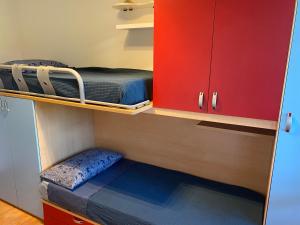 普拉托的住宿－Accanto a Firenze，小房间设有两张双层床和红色橱柜