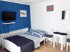 sypialnia z łóżkiem i niebieską ścianą w obiekcie Pokoje Gościnne Galeon w mieście Darłowo