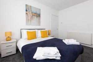 a bedroom with a large bed with towels on it at Connaught House - Wi-Fi, Parking, Contractors in Preston +20 photos