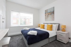 ein weißes Schlafzimmer mit einem großen Bett und gelben Kissen in der Unterkunft Connaught House - Wi-Fi, Parking, Contractors in Preston