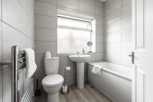 a bathroom with a toilet and a sink and a window at Connaught House - Wi-Fi, Parking, Contractors in Preston