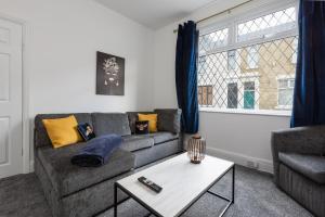 ein Wohnzimmer mit einem Sofa und einem Tisch in der Unterkunft Connaught House - Wi-Fi, Parking, Contractors in Preston