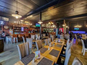 un restaurante con mesas y sillas de madera y un bar en Visually Stunning apartment en Ciudad del Cabo