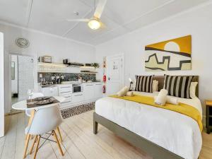 Biała sypialnia z dużym łóżkiem i kuchnią w obiekcie Visually Stunning apartment w Kapsztadzie