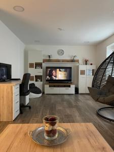 una sala de estar con TV y una mesa con una taza de café. en Ferienhaus Hoti 