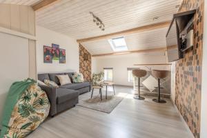 Les Lilas Confort & Nature في فولفيك: غرفة معيشة مع أريكة وتلفزيون