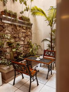 un patio con tavolo, sedie e piante di Hotel Monet a Mar del Plata
