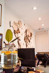 a desk with a computer and a vase with a plant in it at Hotel Monet in Mar del Plata