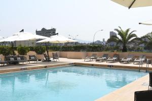 a swimming pool with chairs and umbrellas on a building at Sheraton Lima Historic Center in Lima