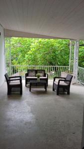 a group of chairs and a table on a porch at Qiwi House in Ureki