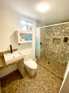 a bathroom with a toilet and a shower and a sink at Azomalli Hotel Boutique in Damían Carmona