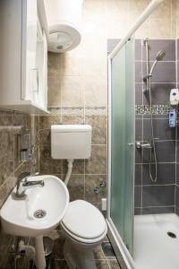 een badkamer met een toilet, een wastafel en een douche bij Center Point in Subotica