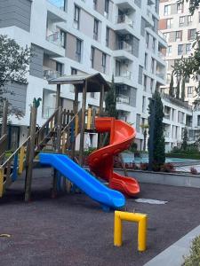 a playground with a slide in front of a building at westsid in Beylikduzu