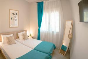 a bedroom with a bed and a window with a mirror at Sophia's Coastal Retreat in Korinos