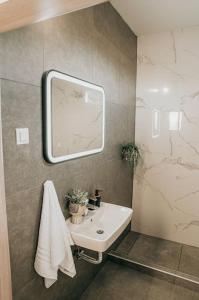 a bathroom with a sink and a mirror at Sophia's Coastal Retreat in Korinos