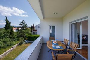 a patio with a table and chairs on a balcony at Apartment Karmen in Šilo