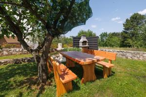 a wooden picnic table sitting next to a tree at Apartment Karmen in Šilo