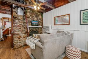 Una sala de estar con un sofá y una pared de piedra. en The Vintage Bear Cabin - wonderful, well appointed cabin with a native rock fireplace!, en Big Bear City