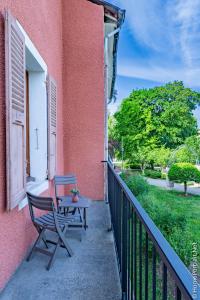 a table and a bench sitting on a balcony at La Vie est belle in Oyonnax