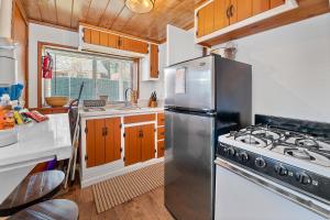 Una cocina con refrigerador de acero inoxidable y estufa. en The Vintage Bear Cabin - wonderful, well appointed cabin with a native rock fireplace!, en Big Bear City