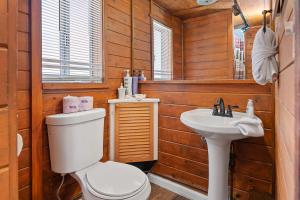 un baño con inodoro y lavabo en The Vintage Bear Cabin - wonderful, well appointed cabin with a native rock fireplace!, en Big Bear City 14 fotos más