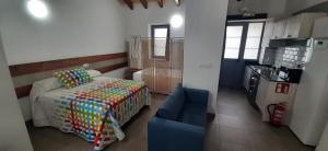 a small bedroom with a bed and a blue chair at El Molino 4 in Muros de Nalón