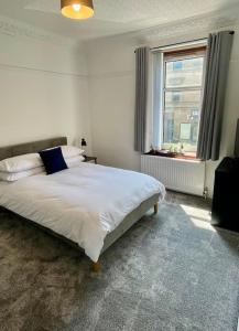 a bedroom with a large white bed with a window at Large 2 bed near Glasgow Airport in Paisley