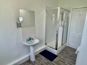 a white bathroom with a shower and a sink at Large 2 bed near Glasgow Airport in Paisley