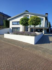 une maison blanche avec deux arbres devant elle dans l'établissement B en B En Route, à Berg en Terblijt