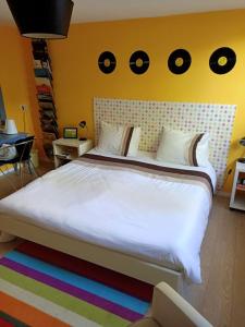a bedroom with a large white bed with circles on the wall at B en B En Route in Berg en Terblijt