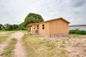a small yellow house on a dirt road at Thackerville Getaway with Porch - Near WinStar! in Thackerville