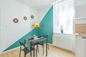 a dining room with a table and chairs at La Vie est belle in Oyonnax